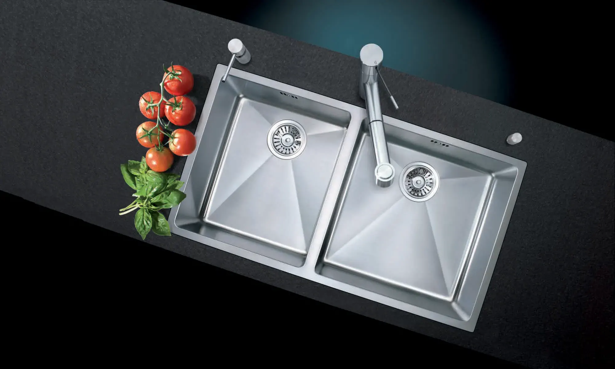 Stainless steel double-bowl kitchen sink with a pull-out mixer tap set into a dark worktop